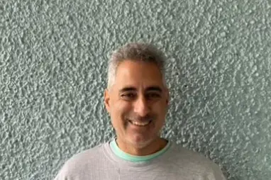 A man with grey hair and a white shirt
